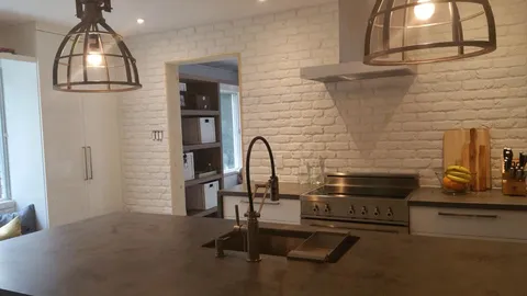 Une cuisine avec de la brique blanche